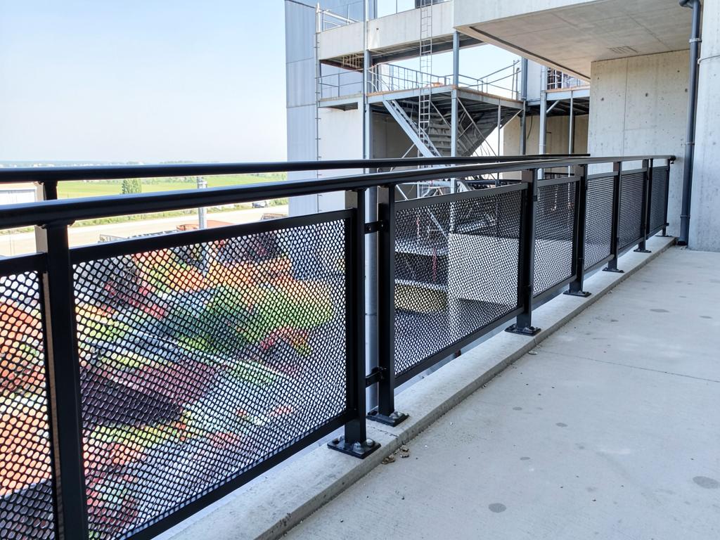 Guarda-corpo com painel de chapa perfurada em passarela industrial