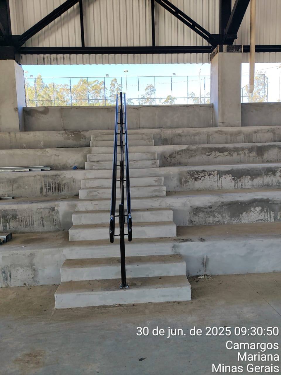 Corrimão central em escada de arquibancada coberta — Camargos, Mariana/MG — fabricado e instalado pela DMA Engenharia e Serralheria